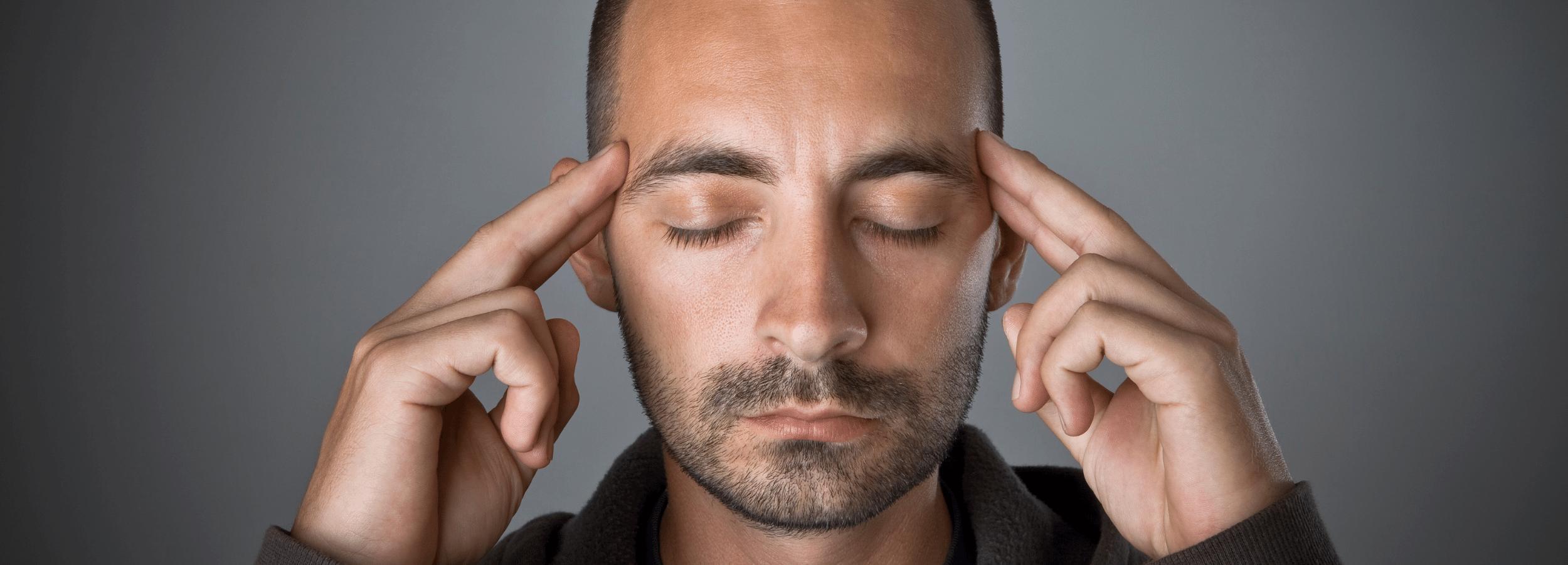 Person with fingers to temples receiving psychic information.