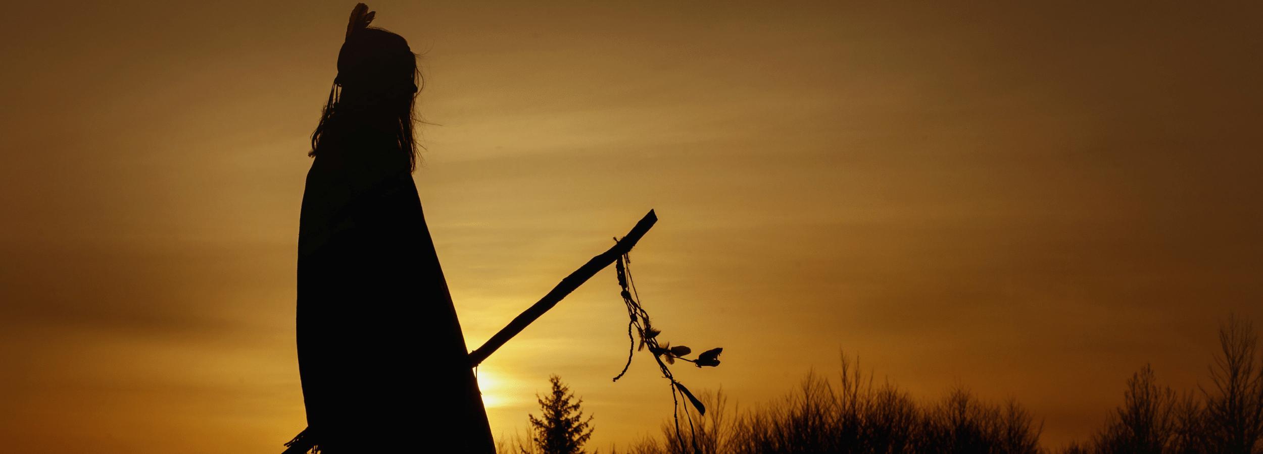 A Native American spirit guide walking through a twilit landscape.